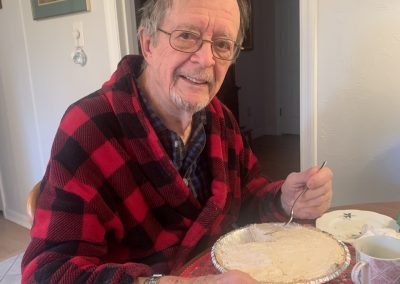 2023-12-20 Pie for Breakfast, photographed by Joy Sherman. “[Husband] Rob’s first little biographical book was entitled “Pie for Breakfast.” Ever since then, I’ve baked a peanut butter pie the day before his birthday, hidden it in the freezer, and presented it to him on his birthday. Here he is, just out of bed Tuesday, on his 93rd birthday enjoying pie for breakfast.” Happy Birthday, Rob! #pieforbreakfast #happybirthday #happy93rdbirthday #peanutbutterpie #baysidemaine