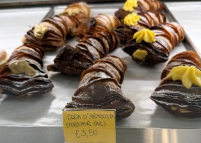 2025-03-18 Coda D’Aragosta (lobster tail), photographed by Angela Cassidy at an indoor food market in Modena, Italy. “A fun take on lobster.” Looks tasty. #lobster #lobstertail #codadaragosta #pastry #bakery #cleverbaking #foodmarket #modenaitaly #baysidemaine