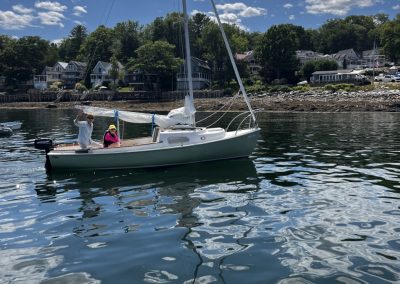 2025-12-17 In and Out, photographed in early August by Cis Lincoln near the Bayside, ME wharf. “After dropping off our friends at the dock, I passed Nan Thorpe and Deanna Wolfire heading into the dock after a sail. They looked so happy and content in Nan‘s boat. Why wouldn’t they be, they had just been sailing on a beautiful day on Penobscot Bay!” #inandout #sailing #backtothedock #thewharf #penobscotbay #baysidemaine